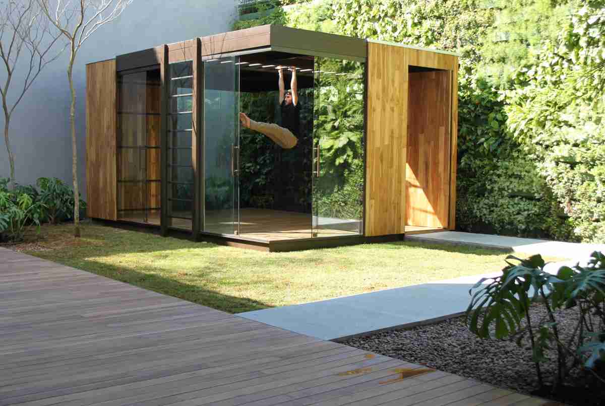 Nesse jardim projetado por Cezar Scarpato, com uma cabana que faz as vezes de sala de ginástica, a grama se tornou um convite para o exercício ao ar livre| Foto: Divulgação