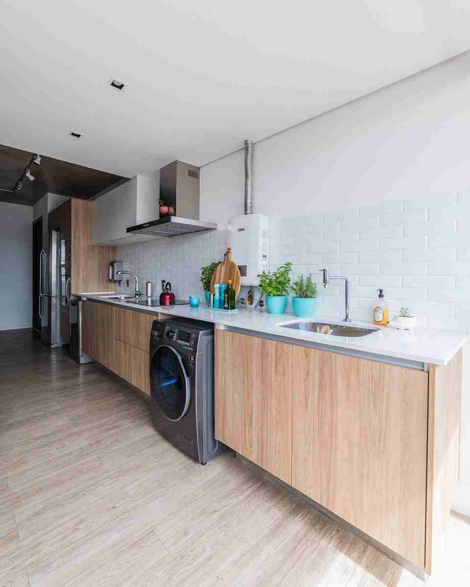 Na cozinha deste apartamento, o aquecedor a gás aparece de maneira discreta. Júlia Guadix utilizou o revestimento da mesma cor do aparelho, promovendo uma espécie de camuflagem. |Foto: Guilherme Pucci