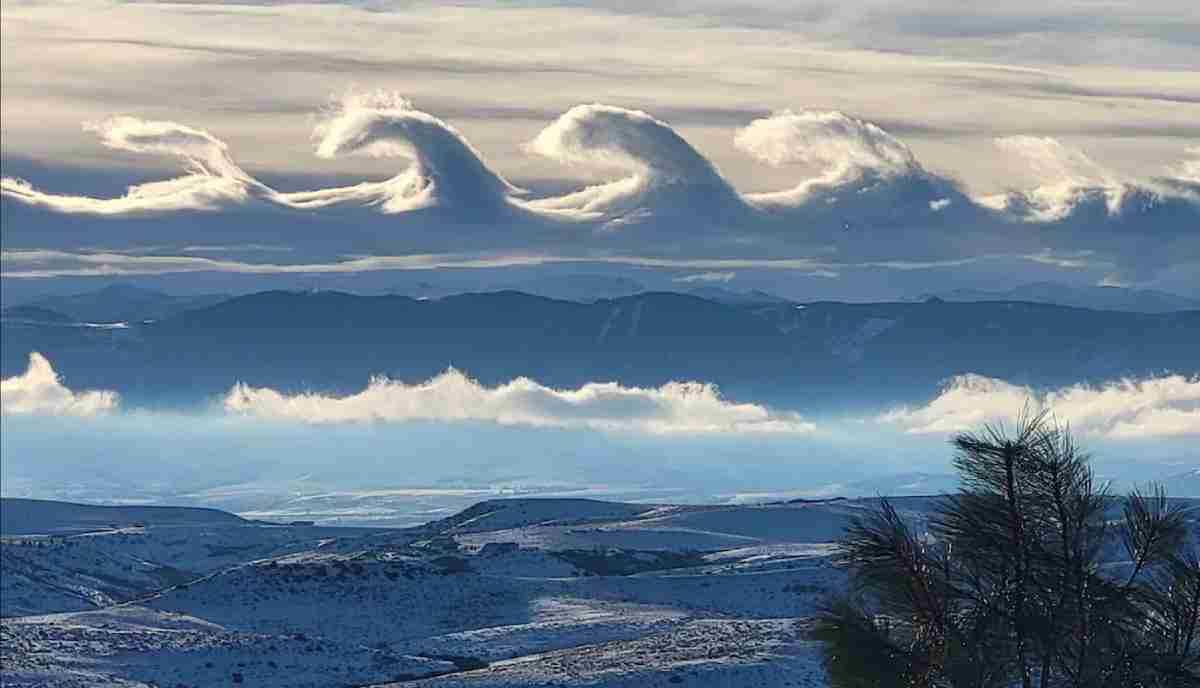 Nuvens em forma de onda flutuam sobre montanhas em imagens espetaculares