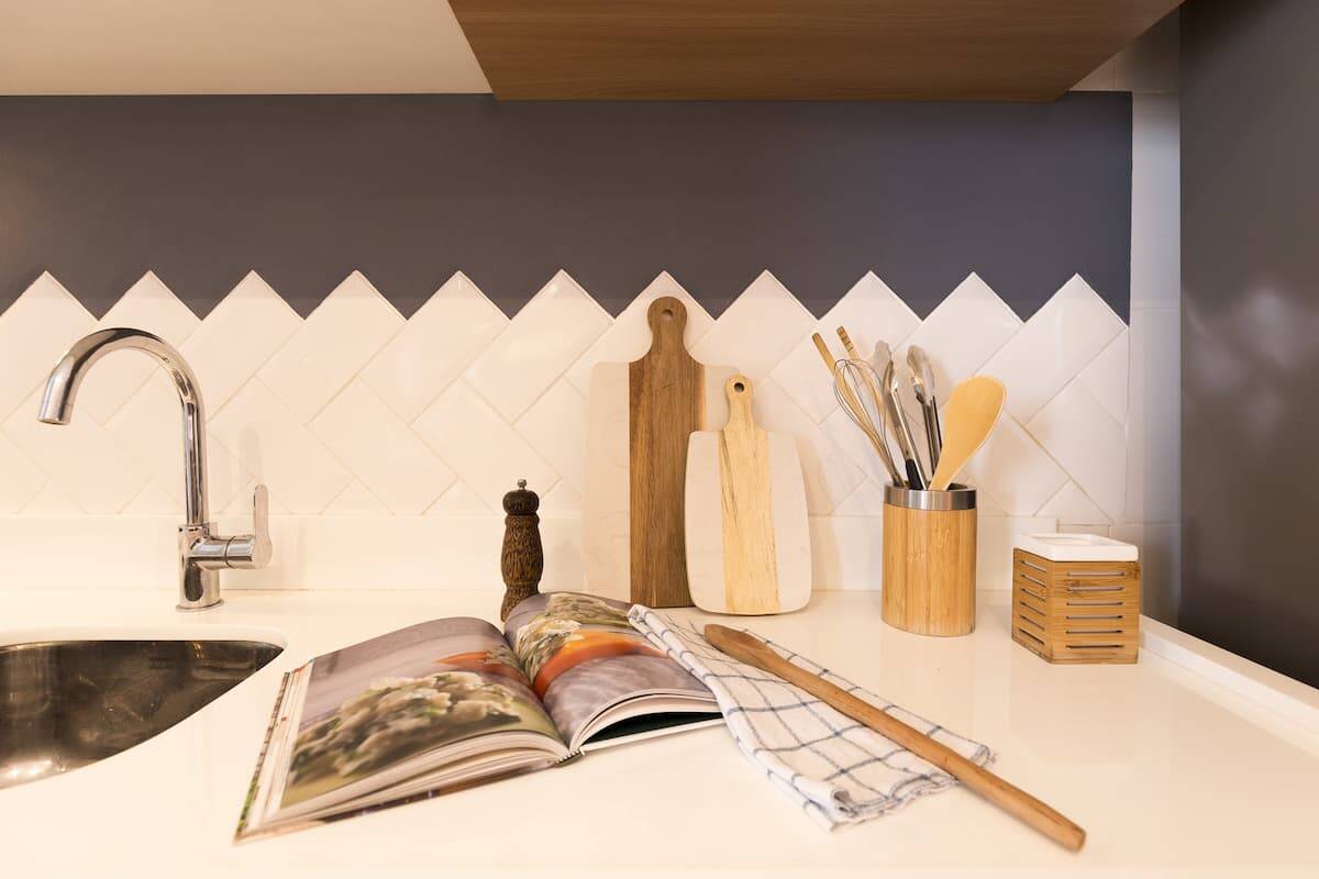 Para essa cozinha, as arquitetas Eduarda Negretti e Nathalia Lena, do Lene Arquitetos, optaram pela meia parede e paginação chevron. Foto: Luciano Sessa